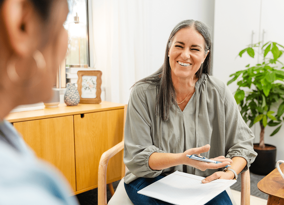 Smiling woman holding a pen